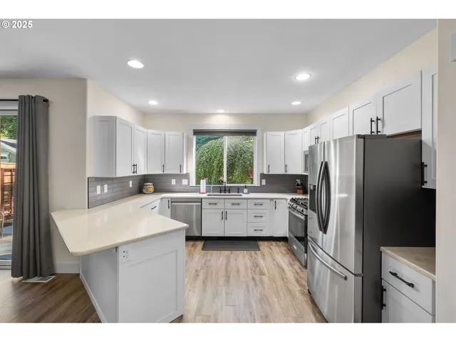 a kitchen with a refrigerator a sink and cabinets