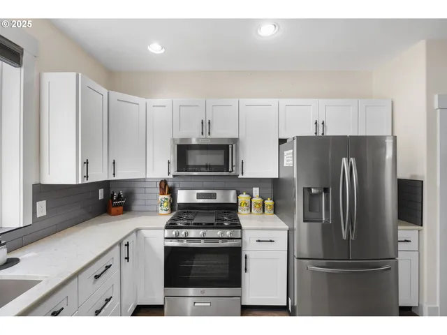 a kitchen with stainless steel appliances a refrigerator a sink a stove a microwave and cabinets