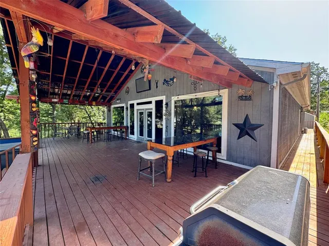 a view of a patio with table and chairs with wooden floor and fence