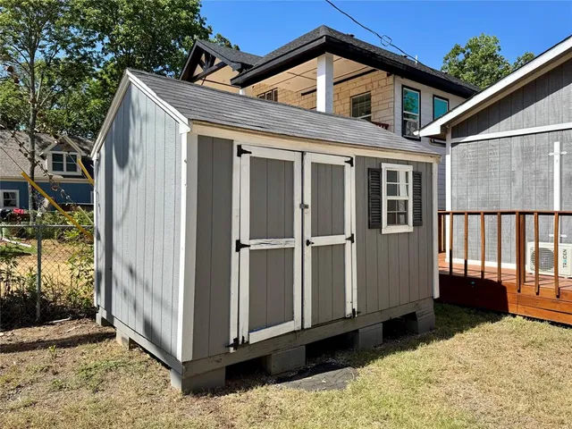 a view of a house with wooden floor and a large tree