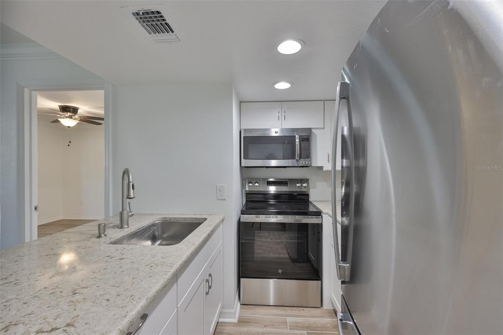 4736 Jasper Drive, Unit 103 New Port Richey, FL 34652 - Photo 13 of 41 a kitchen with stainless steel appliances granite countertop a sink and cabinets