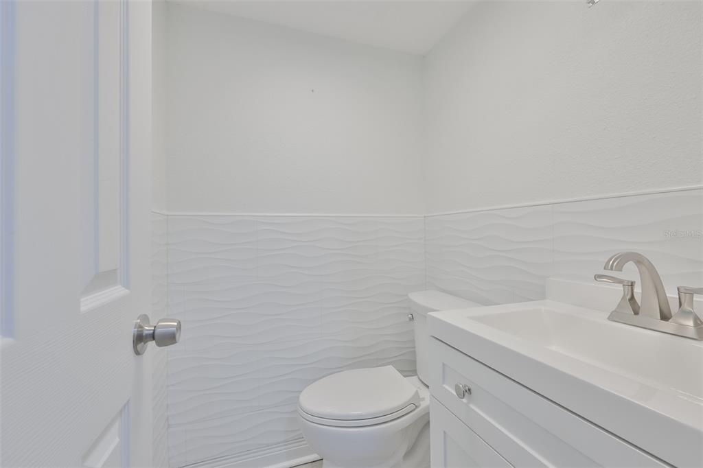 4736 Jasper Drive, Unit 103 New Port Richey, FL 34652 - Photo 30 of 41 a bathroom with a toilet a sink and mirror