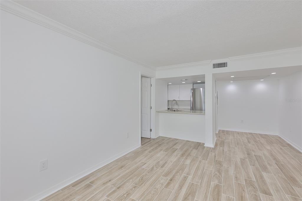 4736 Jasper Drive, Unit 103 New Port Richey, FL 34652 - Photo 8 of 41 a view of an empty room and kitchen with wooden floor