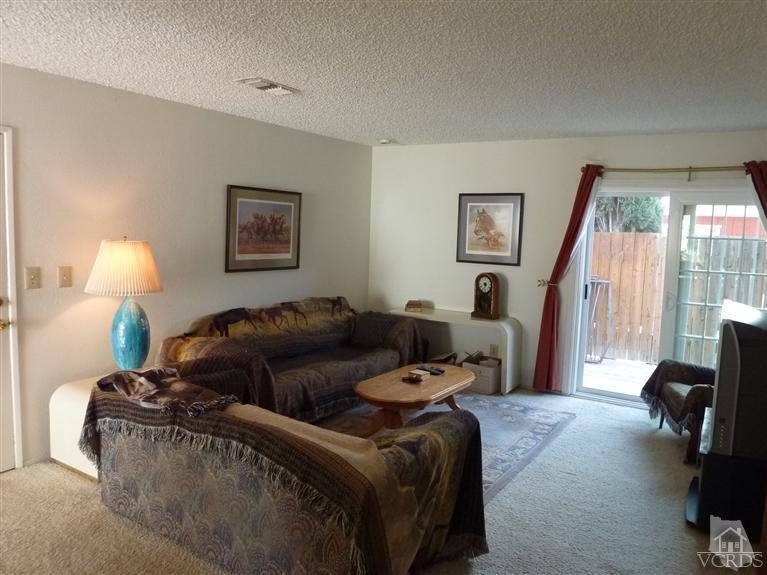 4593 Adam Road Simi Valley, CA 93063 - Photo 3 of 27 a living room with furniture a lamp and a flat screen tv