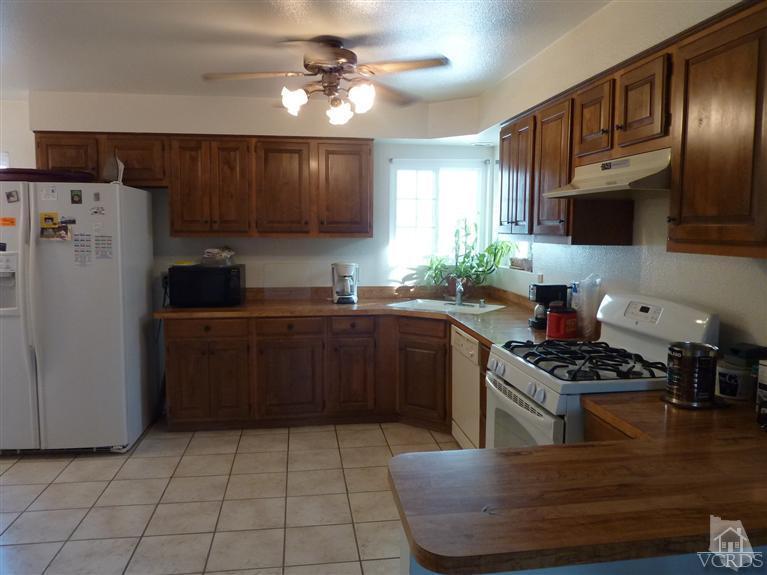 4593 Adam Road Simi Valley, CA 93063 - Photo 4 of 27 a kitchen with kitchen island granite countertop a sink a counter top space cabinets and stainless steel appliances