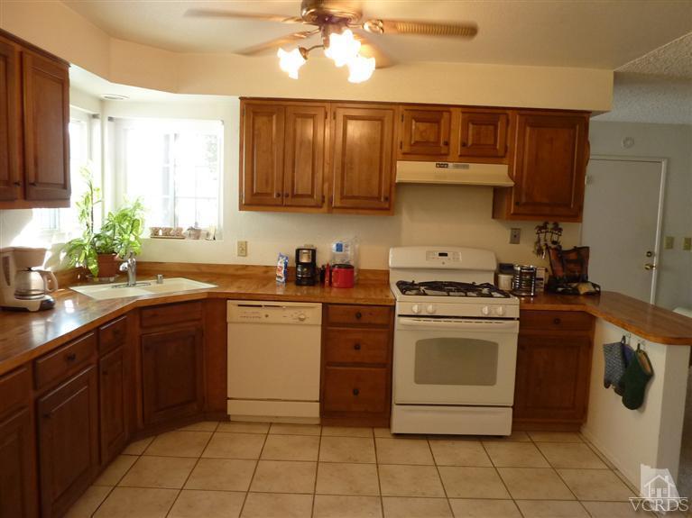4593 Adam Road Simi Valley, CA 93063 - Photo 5 of 27 a kitchen with a stove sink and cabinets