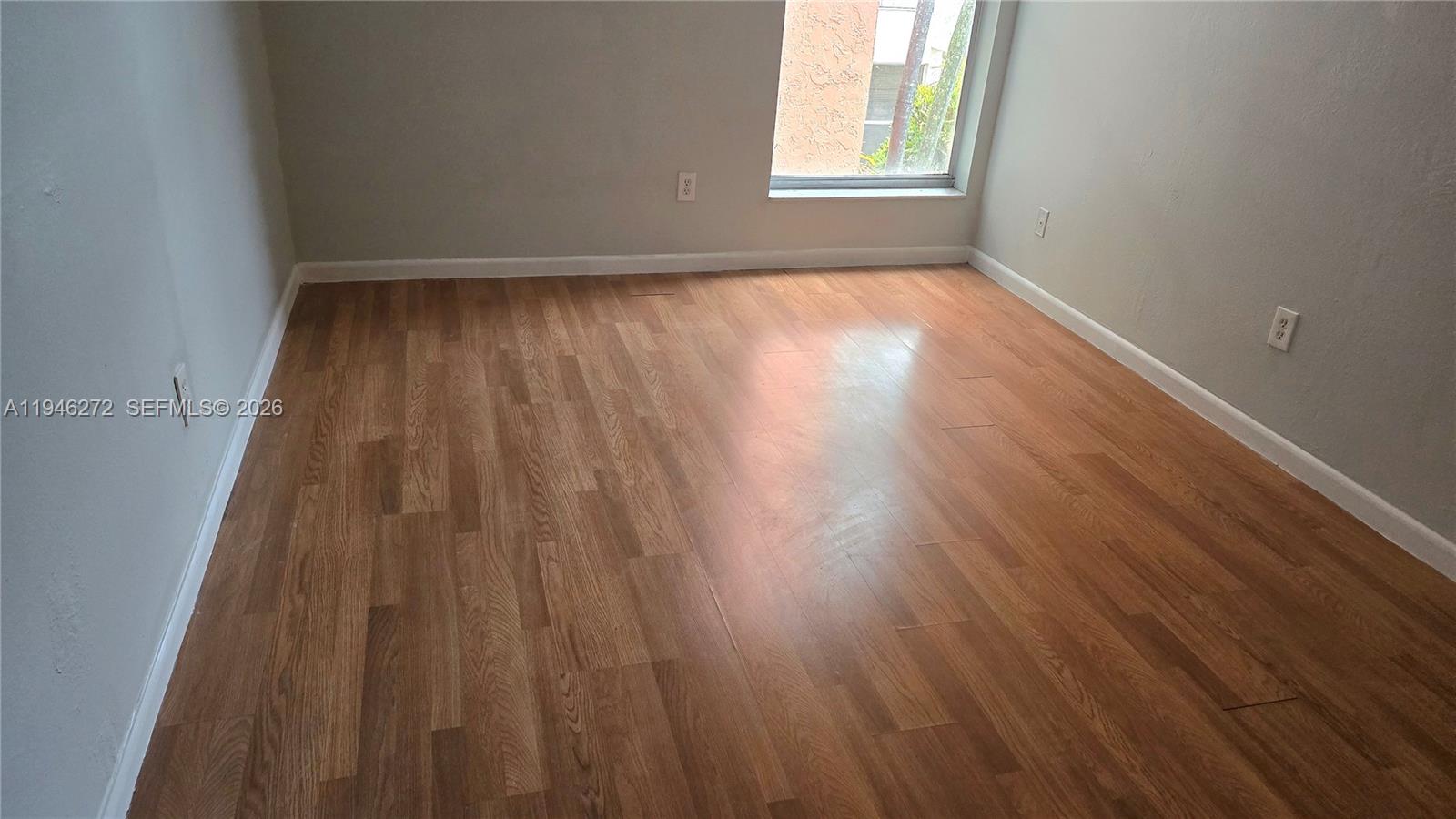2150 Southwest 16th Avenue, Unit 206 Miami, FL 33145 - Photo 7 of 40 an empty room with wooden floor and windows