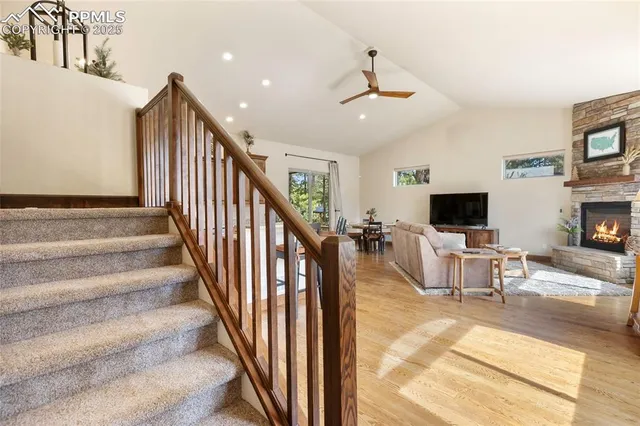 a view of a livingroom with fireplace furniture and a ceiling fan