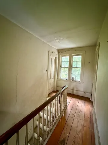 a view of a livingroom with furniture a fireplace and windows
