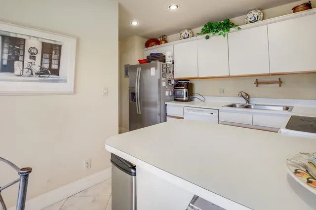 a kitchen with a sink a refrigerator and cabinets
