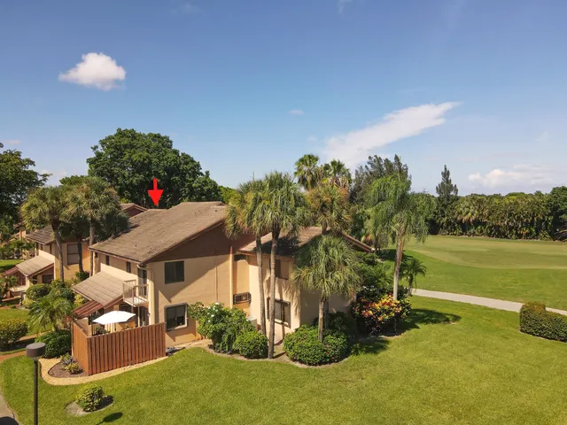 a view of a house with a yard and a pond