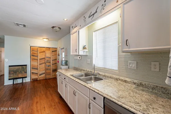 a kitchen with a sink and wooden floor