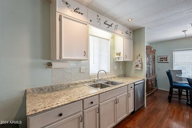 a kitchen with a sink a counter space and wooden floor