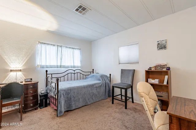 a bedroom with a bed and a dresser in it