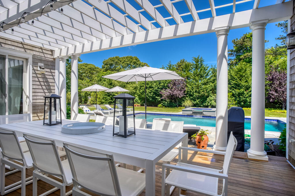 53 Rd To The Plaines Edgartown, MA 02539 - Photo 31 of 35 a view of a patio with table and chairs under an umbrella