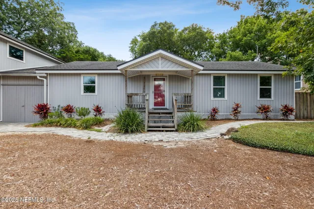 a front view of house with yard and trees in the background