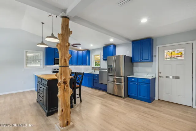 a kitchen with stainless steel appliances wooden cabinets a center island and a refrigerator