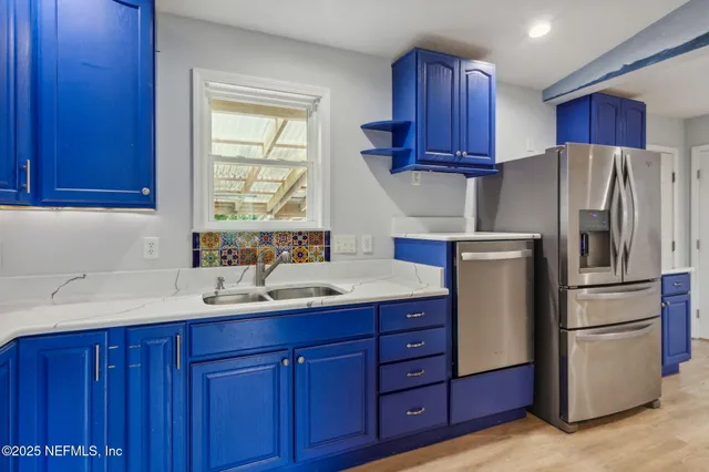 a kitchen with stainless steel appliances granite countertop wooden cabinets a refrigerator and a sink
