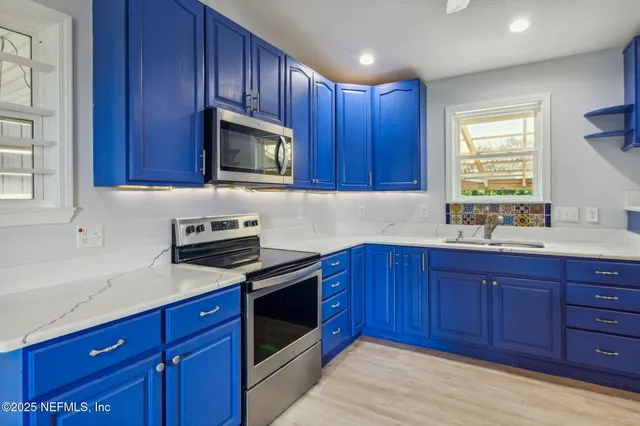 a kitchen with wooden cabinets stainless steel appliances and a window