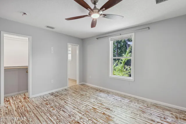 a view of empty room with window and ceiling fan