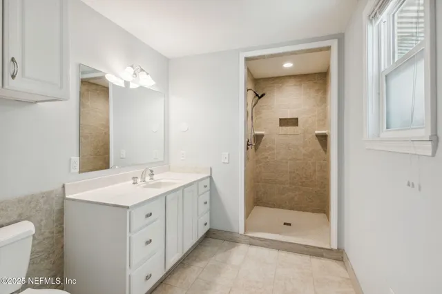 a bathroom with a shower sink and mirror