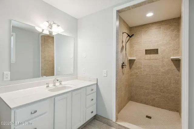 a bathroom with a double vanity sink mirror and shower