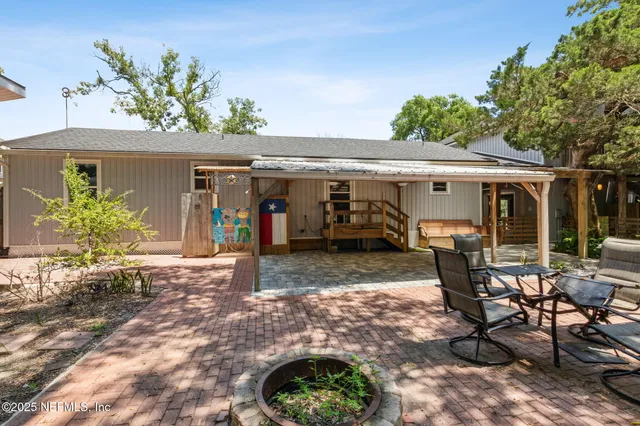 a view of a patio with table and chairs under an umbrella