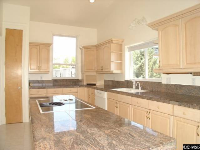 3100 Coronado Way Reno, NV 89503 - Photo 2 of 9 a large white kitchen with granite countertop a sink white cabinets and a window
