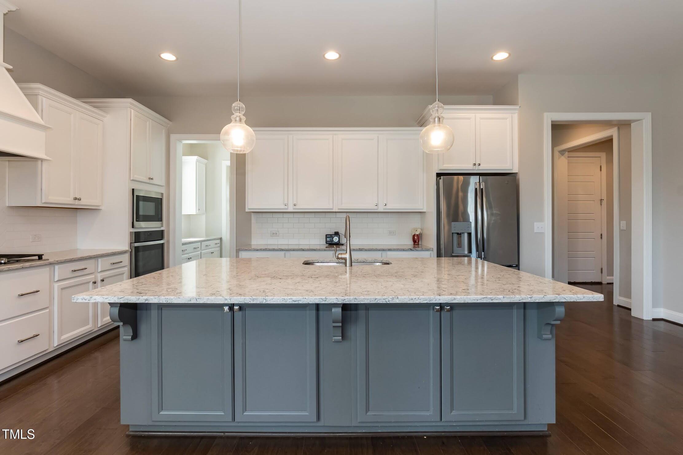 536 Adkins Ridge Road Rolesville, NC 27571 - Photo 25 of 52 a kitchen with kitchen island granite countertop a sink a center island stainless steel appliances and cabinets