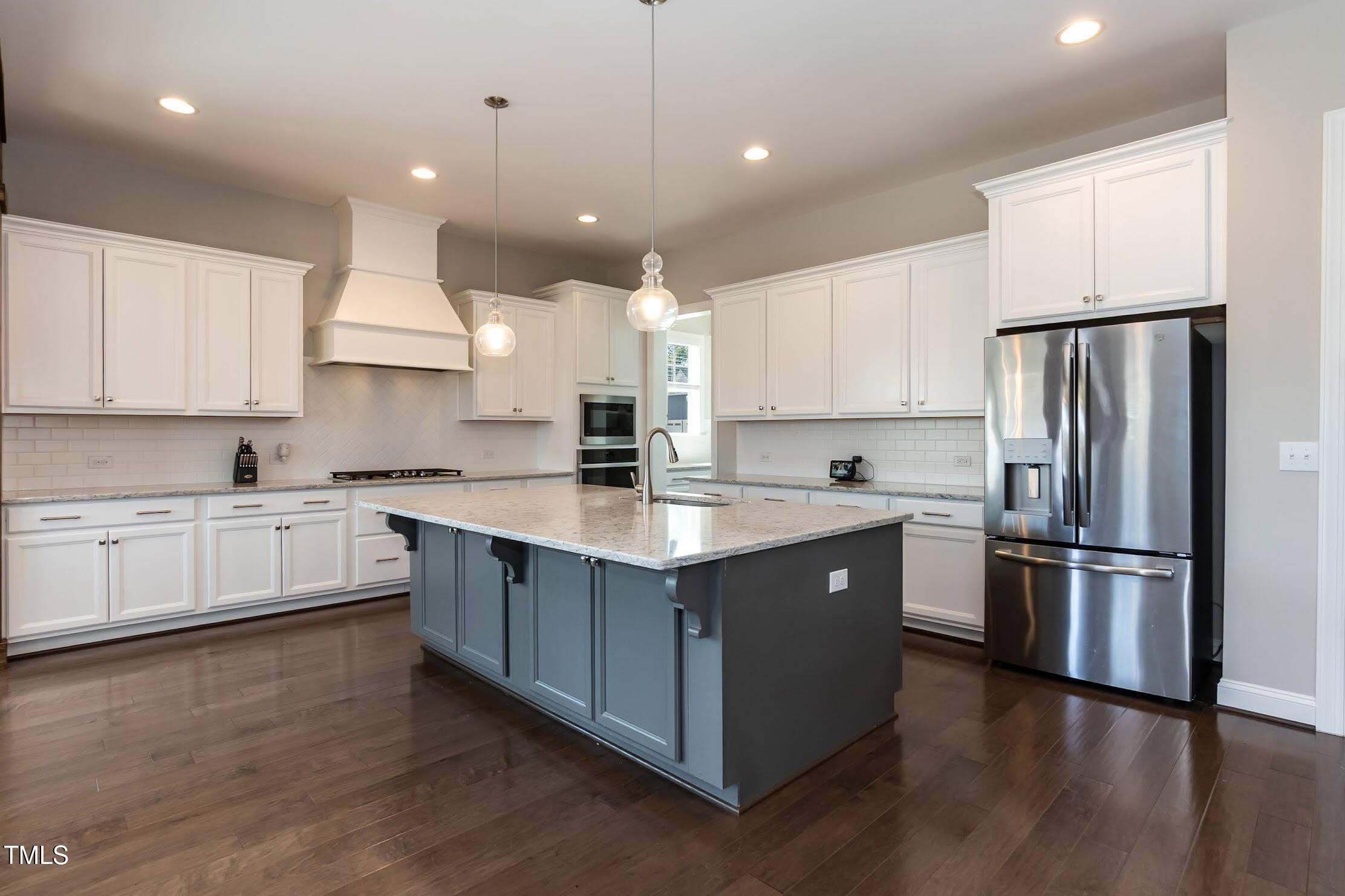 536 Adkins Ridge Road Rolesville, NC 27571 - Photo 26 of 52 a kitchen with kitchen island granite countertop a sink cabinets and stainless steel appliances