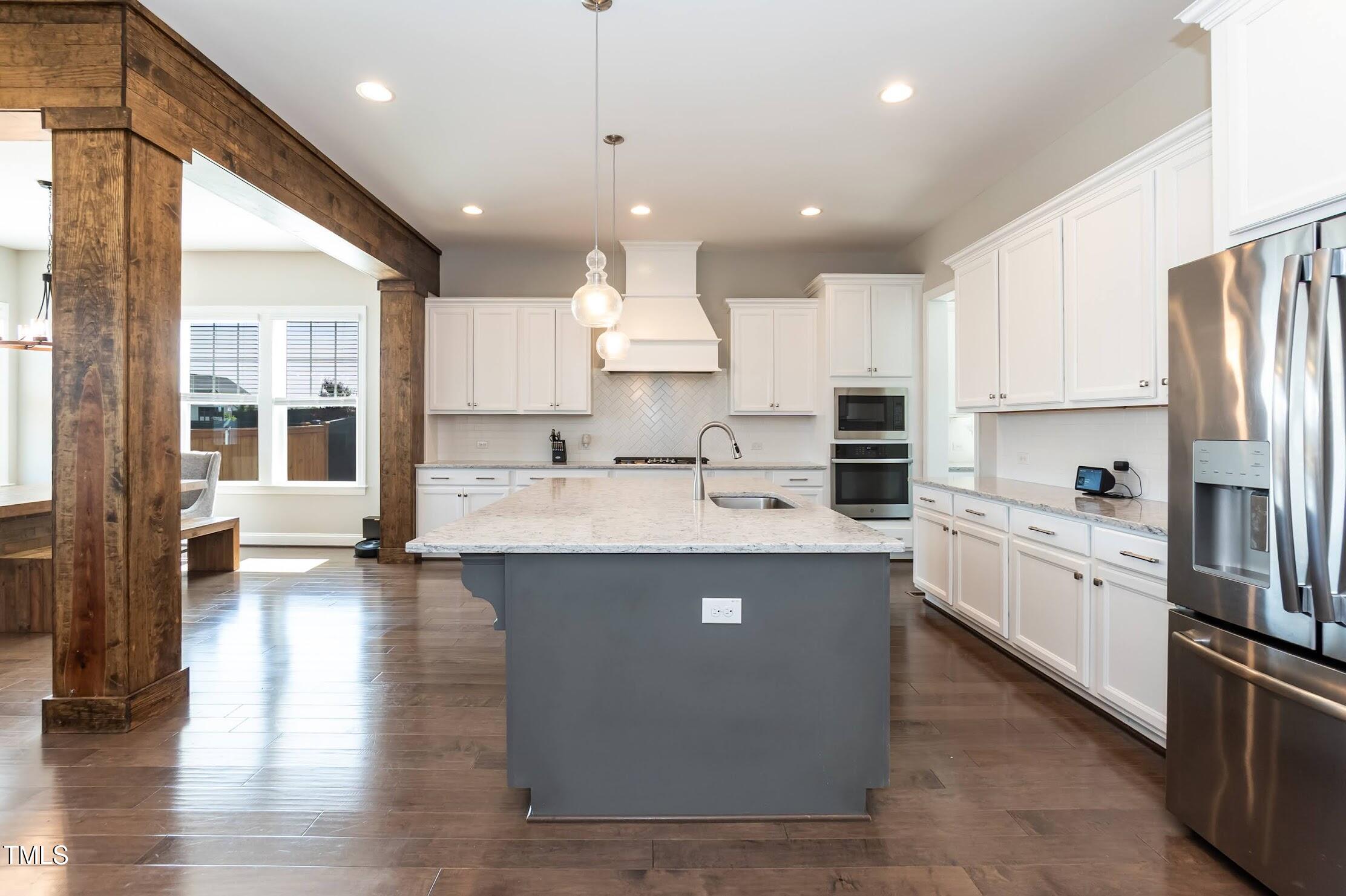 536 Adkins Ridge Road Rolesville, NC 27571 - Photo 27 of 52 a large kitchen with stainless steel appliances kitchen island granite countertop a stove a sink a refrigerator and white cabinets with wooden floor