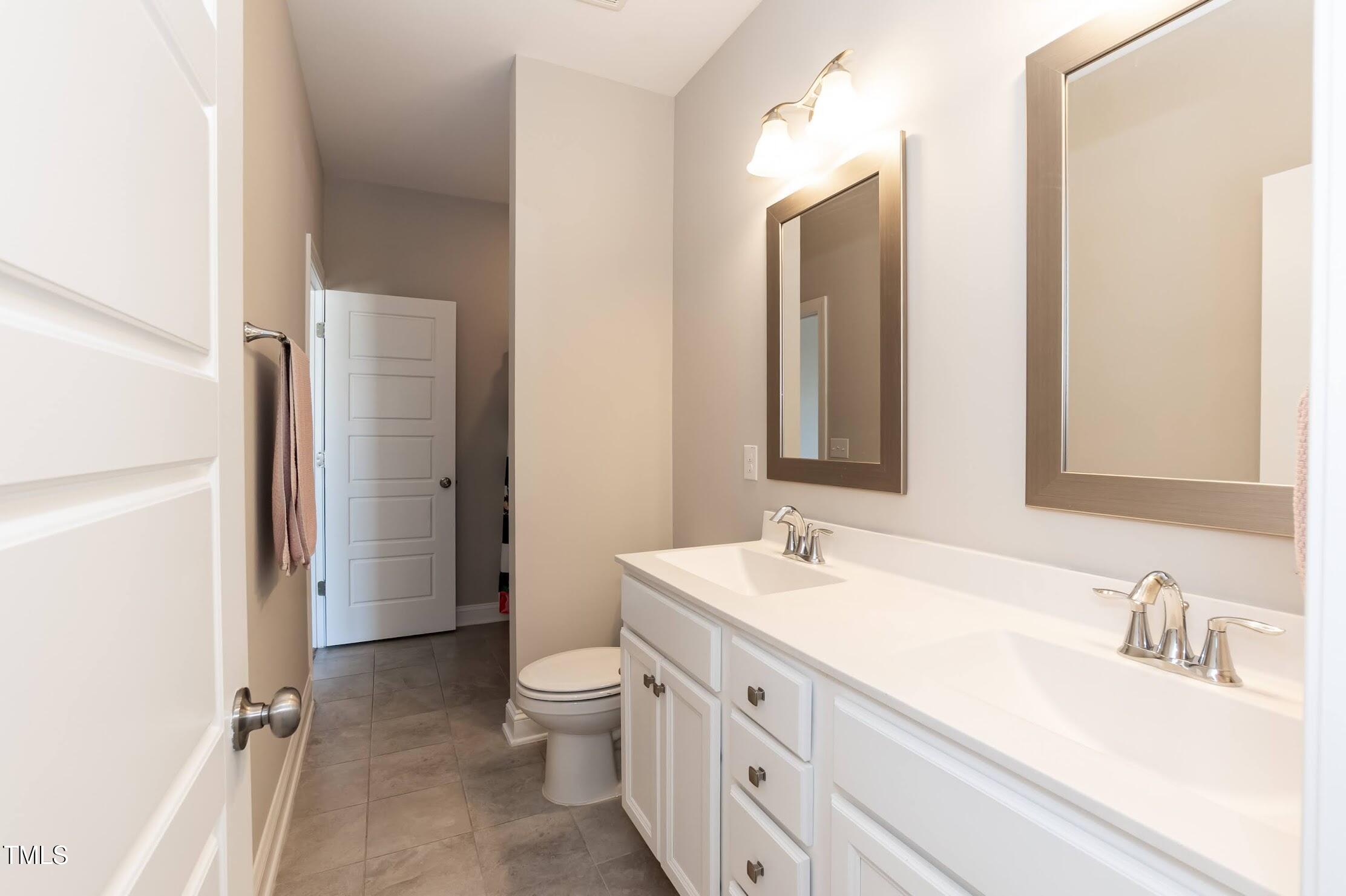 536 Adkins Ridge Road Rolesville, NC 27571 - Photo 44 of 52 a bathroom with a double vanity sink toilet mirror and shower