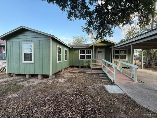 a view of a house with a yard and wooden fence