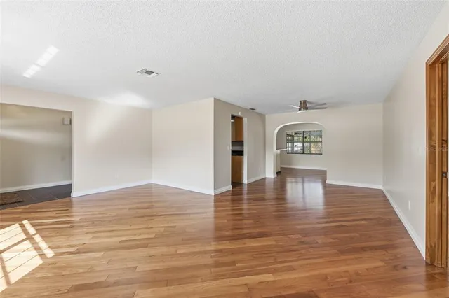 a view of a living room with hardwood floor and a ceiling fan