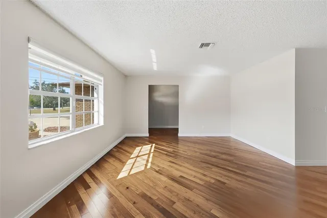 a view of empty room with wooden floor and fireplace