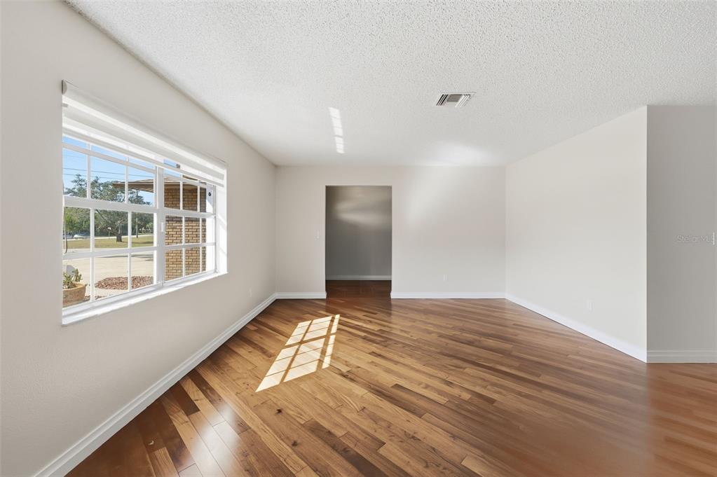 8123 River Country Drive Weeki Wachee, FL 34607 - Photo 24 of 61 a view of an empty room with wooden floor and a window
