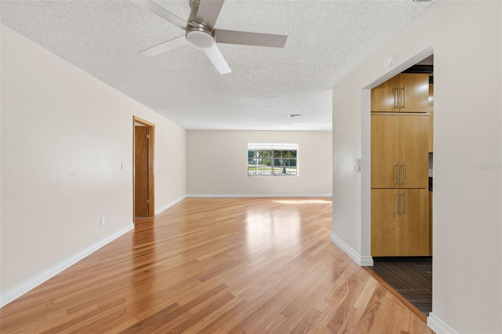 8123 River Country Drive Weeki Wachee, FL 34607 - Photo 26 of 61 a view of a livingroom with wooden floor and a ceiling fan