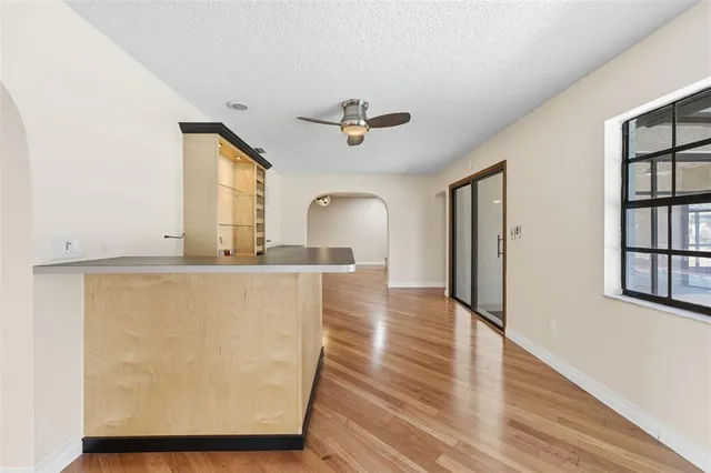 an empty room with wooden floor closet and windows