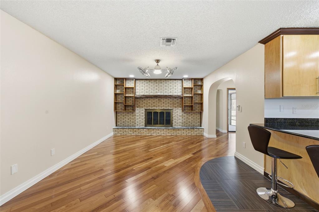 8123 River Country Drive Weeki Wachee, FL 34607 - Photo 33 of 61 a view of an empty room with wooden floor and a fireplace