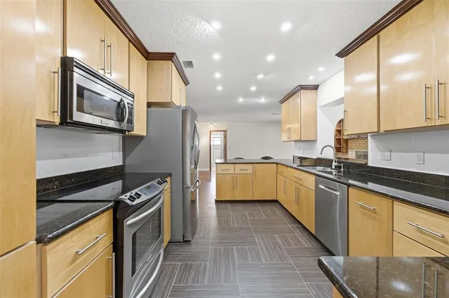 a kitchen with stainless steel appliances granite countertop a sink and cabinets