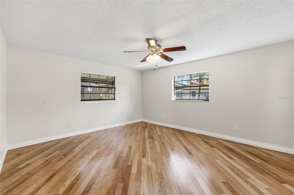 8123 River Country Drive Weeki Wachee, FL 34607 - Photo 39 of 61 a view of empty room with wooden floor and fan