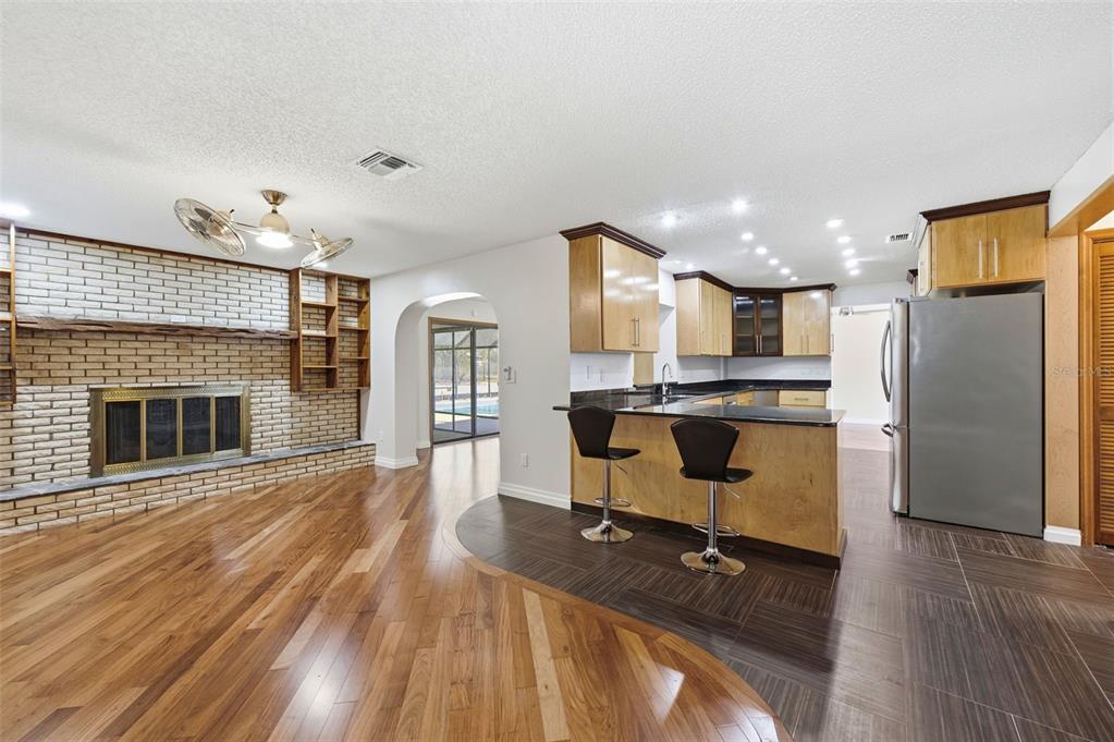 8123 River Country Drive Weeki Wachee, FL 34607 - Photo 50 of 61 a living room with stainless steel appliances kitchen island granite countertop furniture and a fireplace