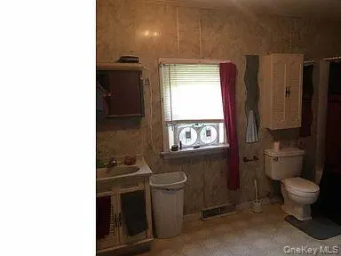 a bathroom with a toilet sink and mirror