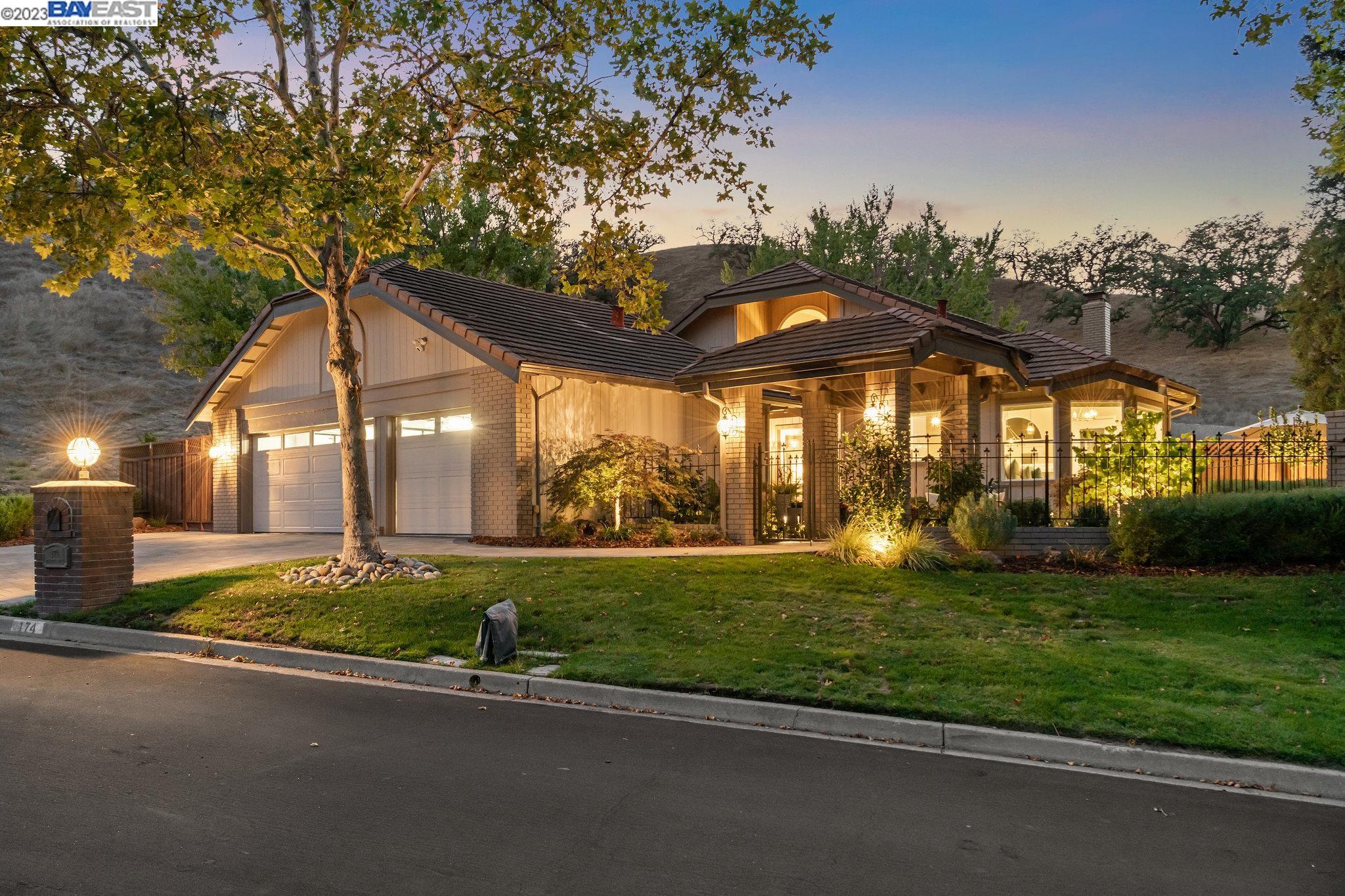 a view of a house with a big yard plants and large trees