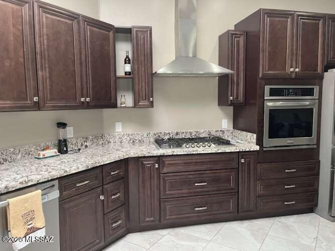 11553 East Tanque Verde Road Tucson, AZ 85749 - Photo 12 of 16 a kitchen with granite countertop wooden cabinets and stainless steel appliances