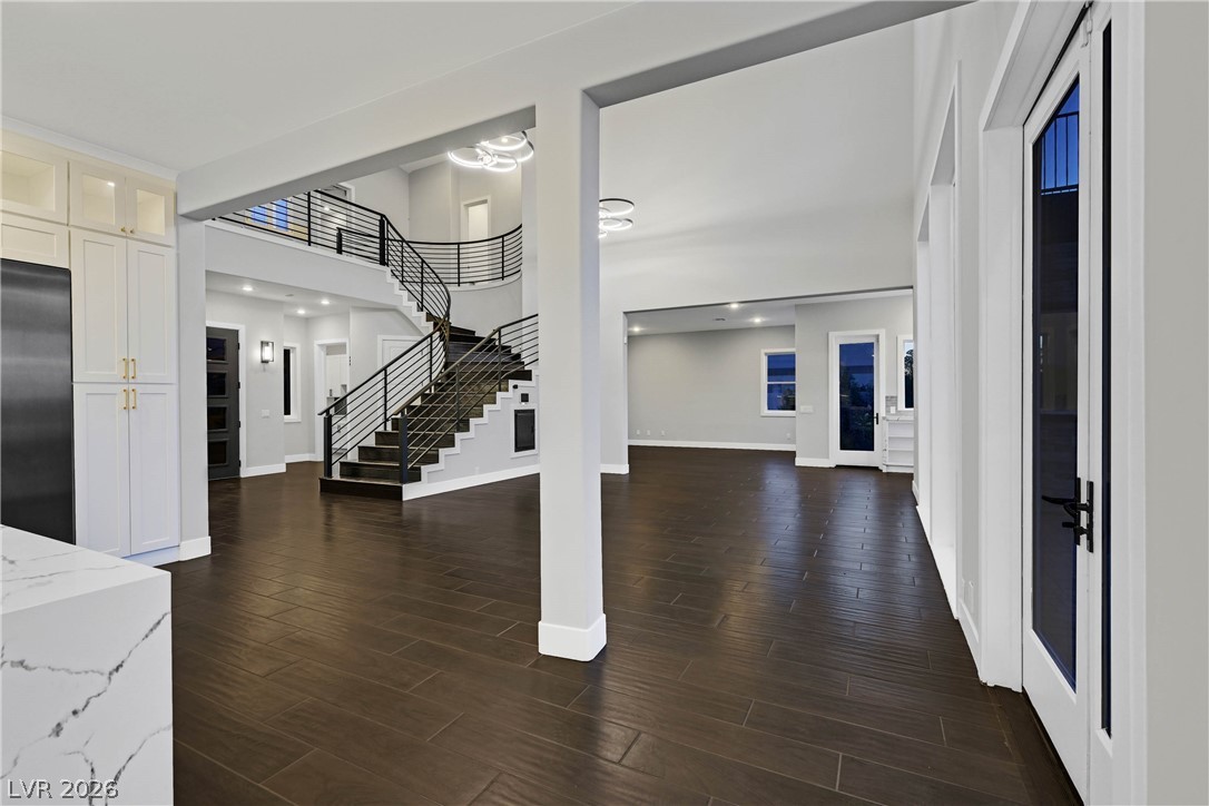 6 Rue Du Ville Henderson, NV 89011 - Photo 44 of 99 Grand open-concept living space with a striking curved staircase and gleaming hardwood floors.