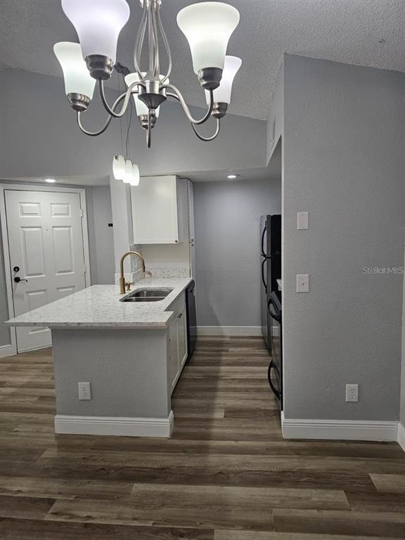 5132 Conroy Road, Unit 932 Orlando, FL 32811 - Photo 3 of 19 a view of a hallway with wooden floor and chandelier