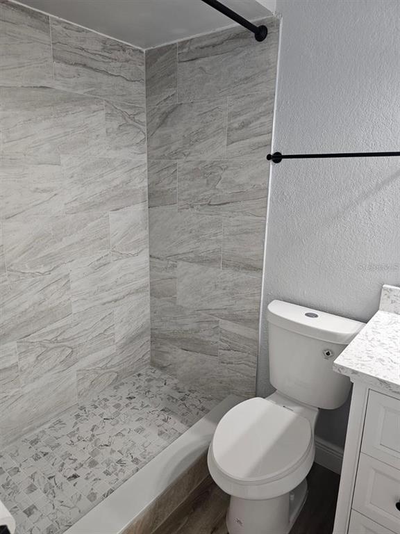 5132 Conroy Road, Unit 932 Orlando, FL 32811 - Photo 7 of 19 a toilet sitting in a bathroom next to a wooden wall