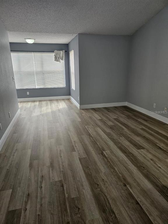5132 Conroy Road, Unit 932 Orlando, FL 32811 - Photo 10 of 19 wooden floor in an empty room with a window