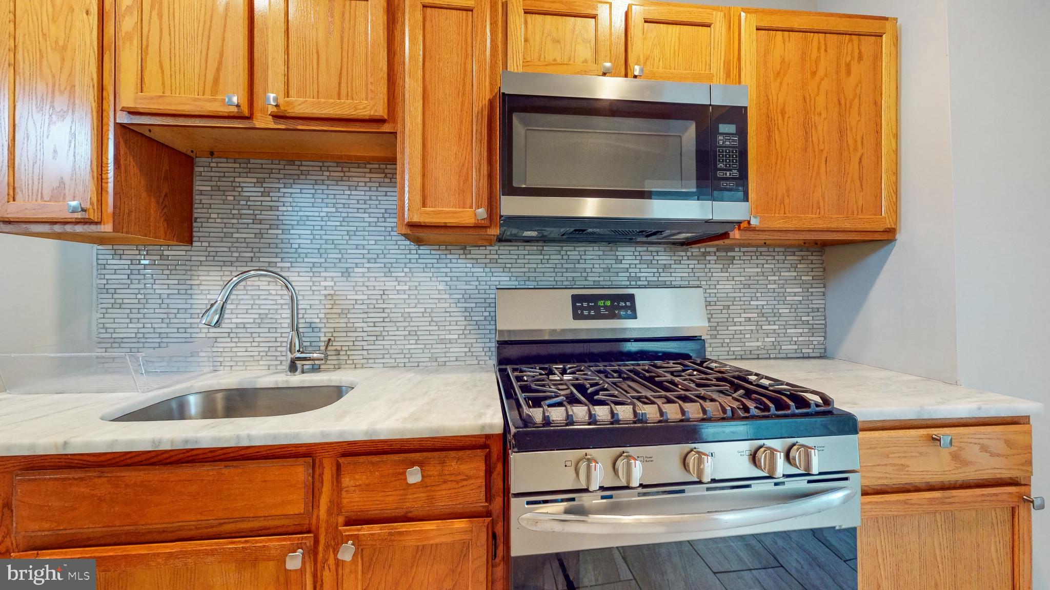 812 McCabe Avenue Baltimore, MD 21212 - Photo 11 of 18 a kitchen with stainless steel appliances granite countertop a stove a sink and a microwave